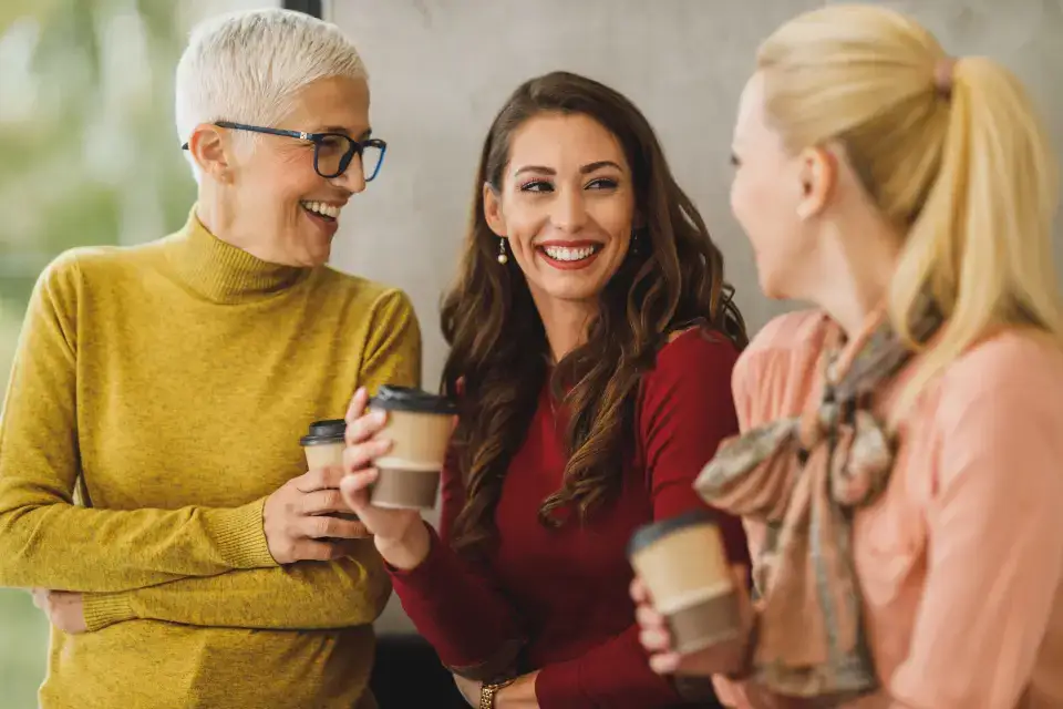 Compañeras de trabajo conversando de manera cordial en la oficina
