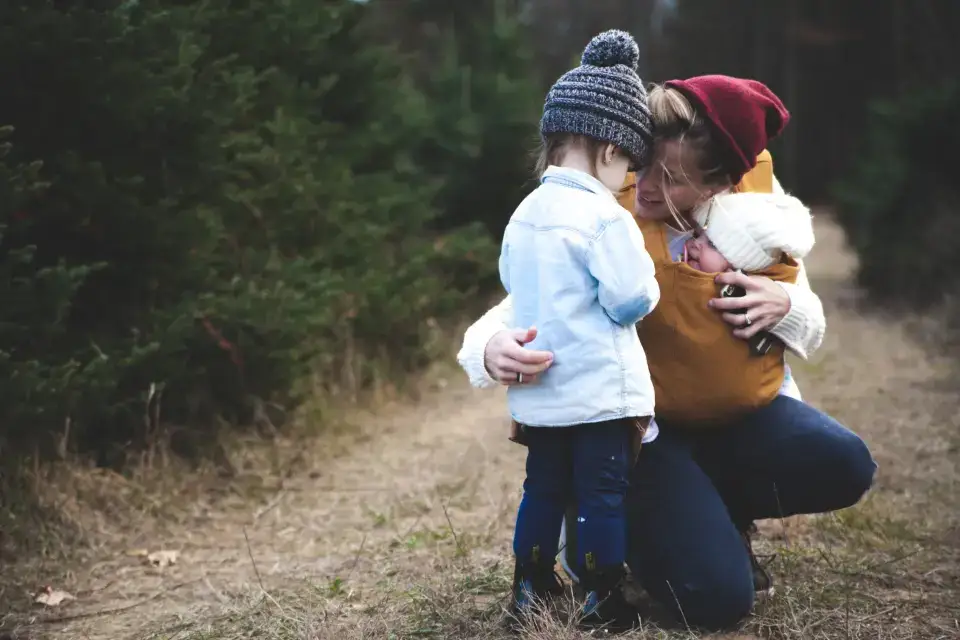Madre abrazando a su hijo pequeño al aire libre